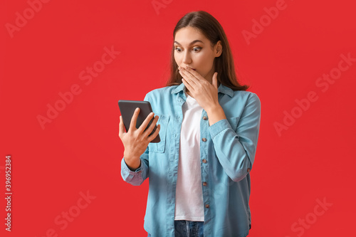 Shocked young woman with e-...
