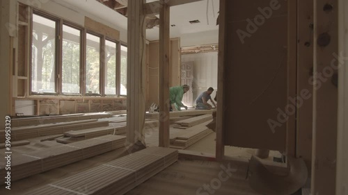 Construction workers begin to lay hardwood floors