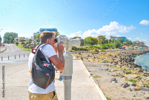 Man looking through spyglass in Slanchev Bryag, Bulgaria photo