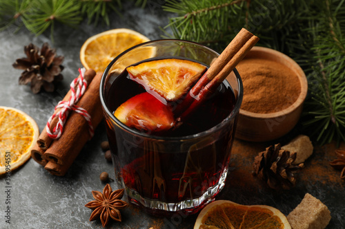 Obraz na plátne Glass of mulled wine and ingredients on black smokey background