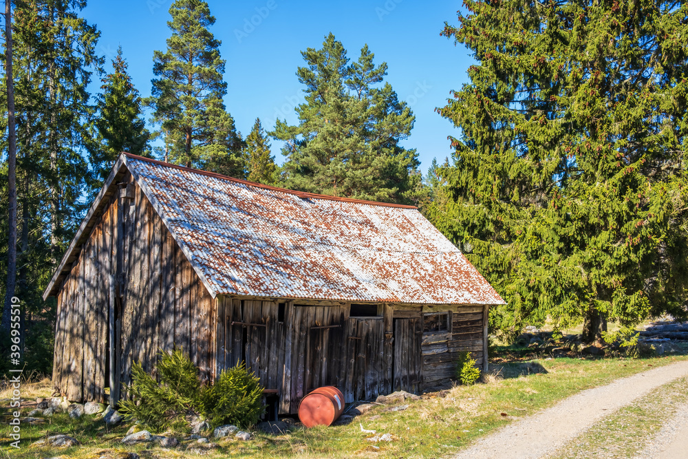 Old weathered barn by a dirt road in the woodland Old weathered barn by a dirt road in the woodland