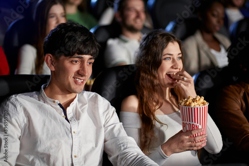 Caucasian couple laughing in movie theater.