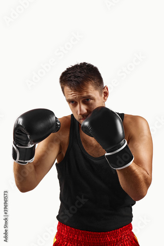 sporty man in black boxing gloves punching isolated on white background.