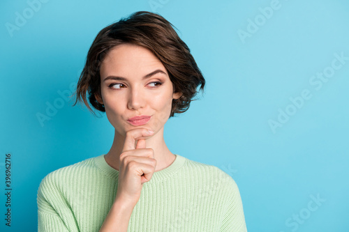 Portrait of cute thinking short hairdo girl hand chin wear lime sweater isolated on teal color background