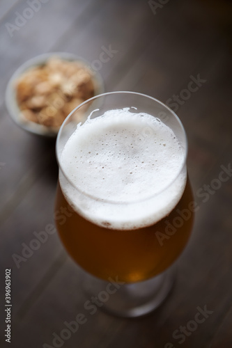 Glass of beer on dark wooden background. 