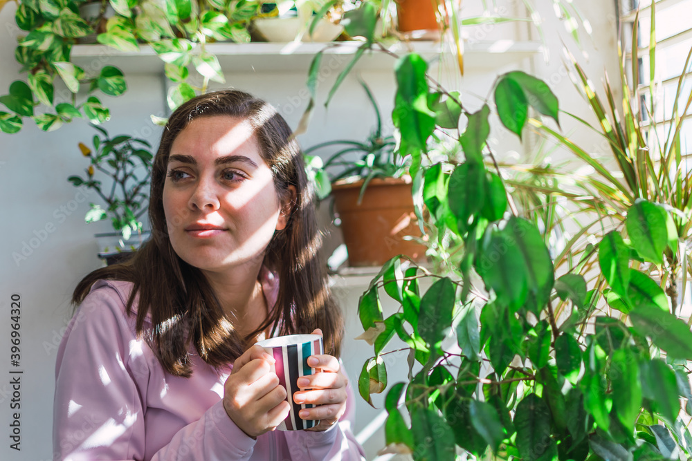 Young white woman drinking coffee on a balcony Young white woman drinking coffee on a balcony