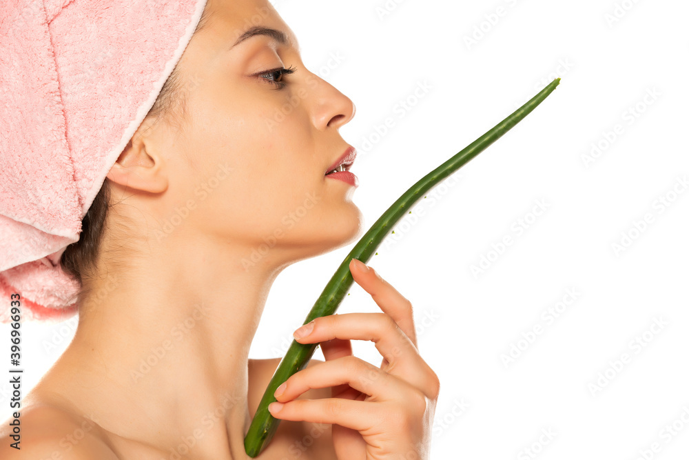 Young shirtless woman posing with a leaf of aloe vera Young shirtless woman posing with a leaf of aloe vera