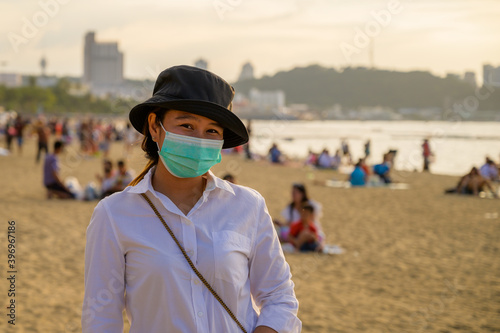 Young woman wearing face mask travel on the beach in Thailand.,Travel concept new normal background.during coronavirus or covid-19 virus outbreak. © Hide_Studio