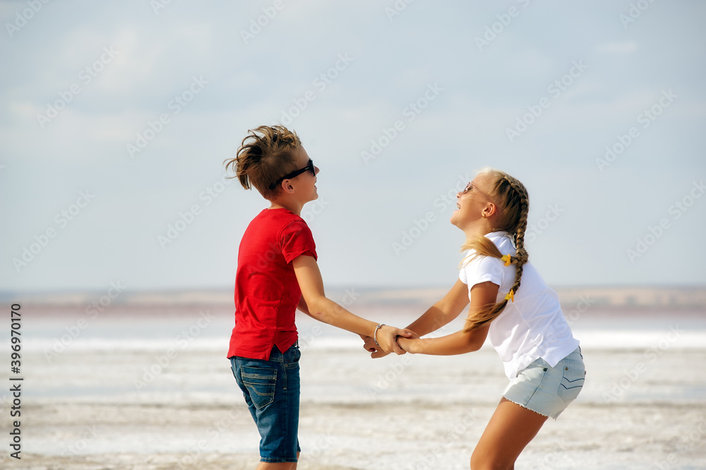 Cheerful children in nature. A boy and a girl are having fun on vacation.