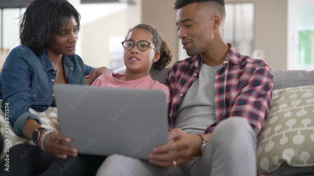 Happy family of three connected with laptop to communicate with relatives Happy family of three connected with laptop to communicate with relatives