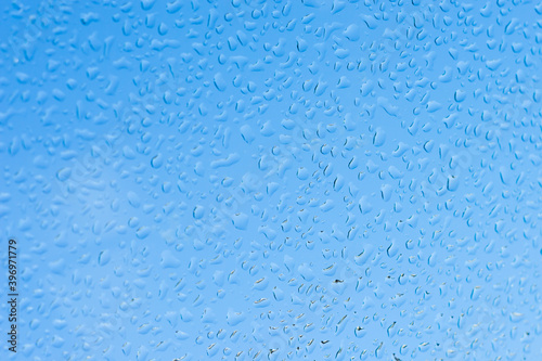 Water drops on glass and blue background.