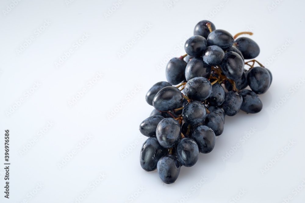 Grapes-clusters of ripe red grapes lie on a white background.Space for text