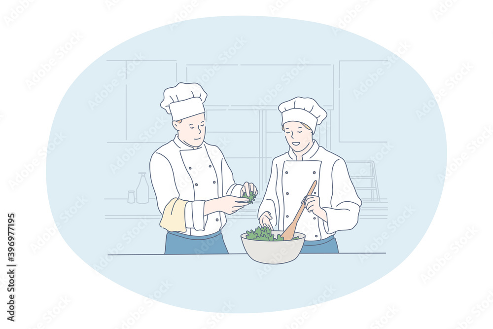 Cooking, professional chef, restaurant concept. Young man and woman professional cooks in aprons and hats cooking healthy salad or dish together in kitchen of cafe Gourmet, delicious, tasty menu 