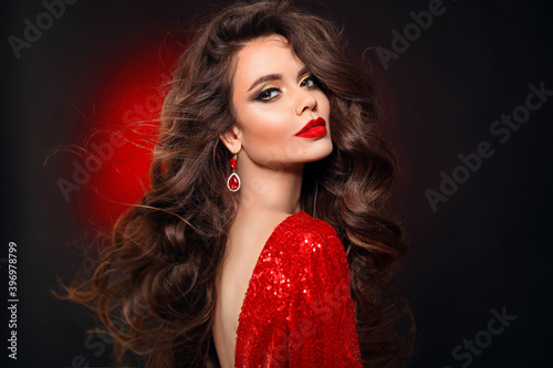Obraz na plátně Beautiful sexy brunette in red dress with healthy curly hair and glamour makeup