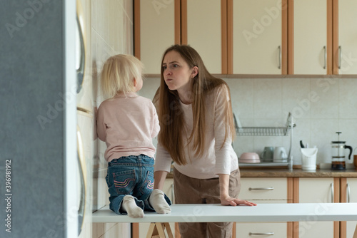 Mom is angry at little child standing in the kitchen