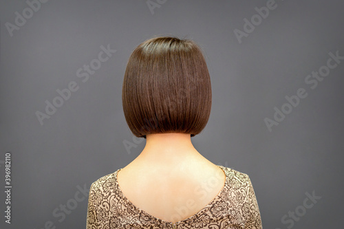 Foto Back view of bob hair of a young woman on dark background