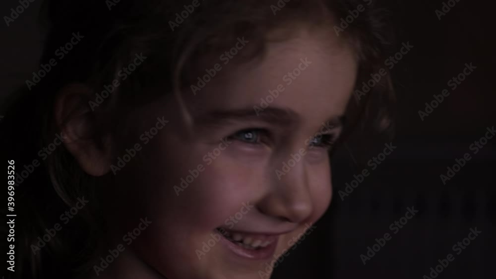 Portrait Сute Little Kid While Watching TV. Young Girl Watch Television on Living Room. Concept Video Game, Entertainment, Emotions, Family. Child Watching TV, Close up Face of Little Girl, Kid Eyes. Portrait Сute Little Kid While Watching TV. Young Girl Watch Television on Living Room. Concept Video Game, Entertainment, Emotions, Family. Child Watching TV, Close up Face of Little Girl, Kid Eyes.
