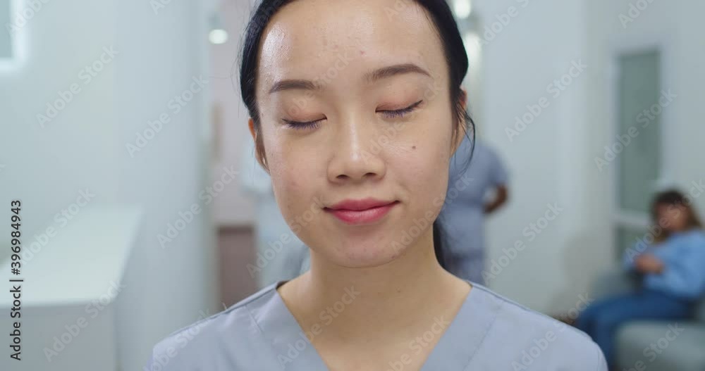 Close up portrait of beautiful Asian woman medical worker standing in hospital, looking at camera with happy face. Young female physician at work in clinic. Healthcare professional concept Close up portrait of beautiful Asian woman medical worker standing in hospital, looking at camera with happy face. Young female physician at work in clinic. Healthcare professional concept