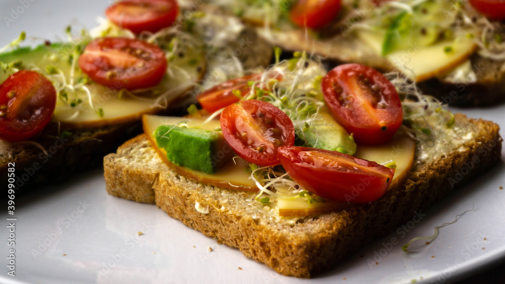 Appetizing and nutritious sandwich with avocado, cheese and tomatoes