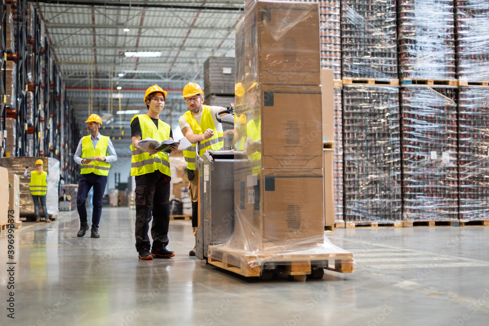 Employees consult while working in the warehouse Employees consult while working in the warehouse