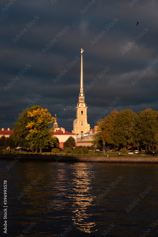 Autumn stormy sunset with dark clouds in front of Peter and Paul fortress in Saint-Petersburg, Russia, birds