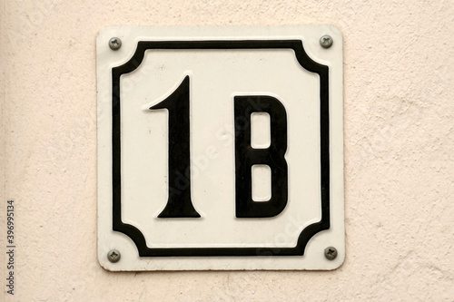 Hausnummernschild Nr. Eins B auf heller Hauswand, Deutschland, Europa photo