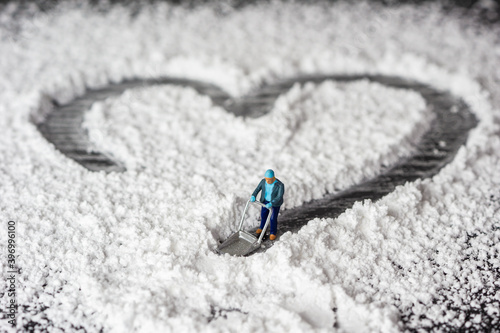a miniature person pushing snow