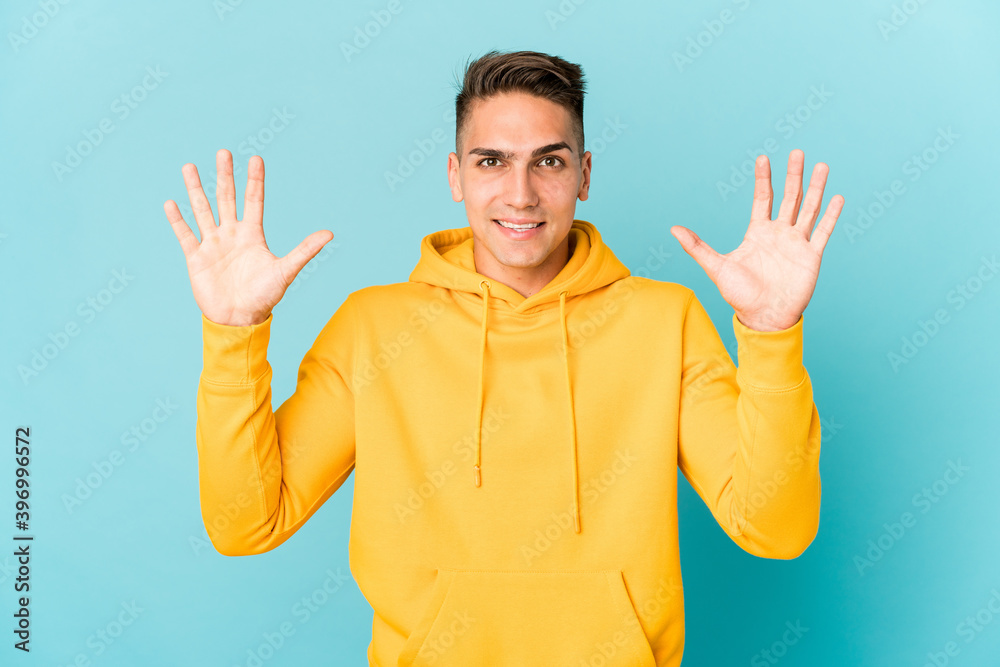 Naklejka premium Young caucasian handsome man isolated receiving a pleasant surprise, excited and raising hands.