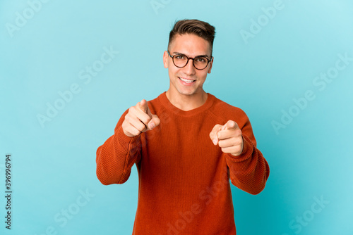 Young caucasian handsome man isolated cheerful smiles pointing to front.