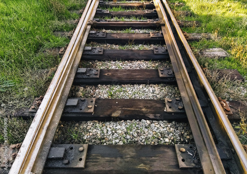Old, dirty, oiled rails and wooden sleepers on the railroad. Photo, top view.