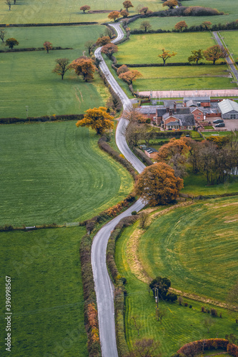 Vertical image long windy road cutting through English Countryside in Cheshire. Aerial shot during a cold day in November photo