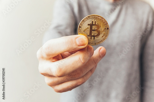 Man hand holding cryptocurrency golden bitcoin coin. Electronic virtual money for web banking and international network payment. Symbol of crypto virtual currency. Mining concept.