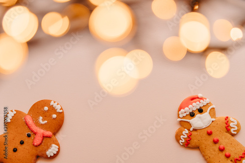 Gingerbread masked man cookies on the background with unfocused lights: New Year and Christmas celebration in a coronavirus pandemic