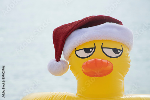 Fotografie YELLOW INFLATABLE LIFEGUARD DUCK WITH SANTA CLAUS HAT ON THE SHORES OF A CARIBB
