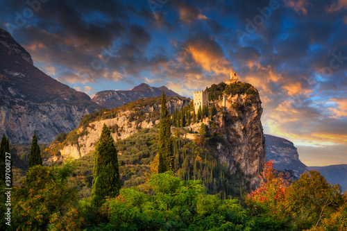 Amazing ruins of Arco Castle on the cliff in northern Italy at sunset.