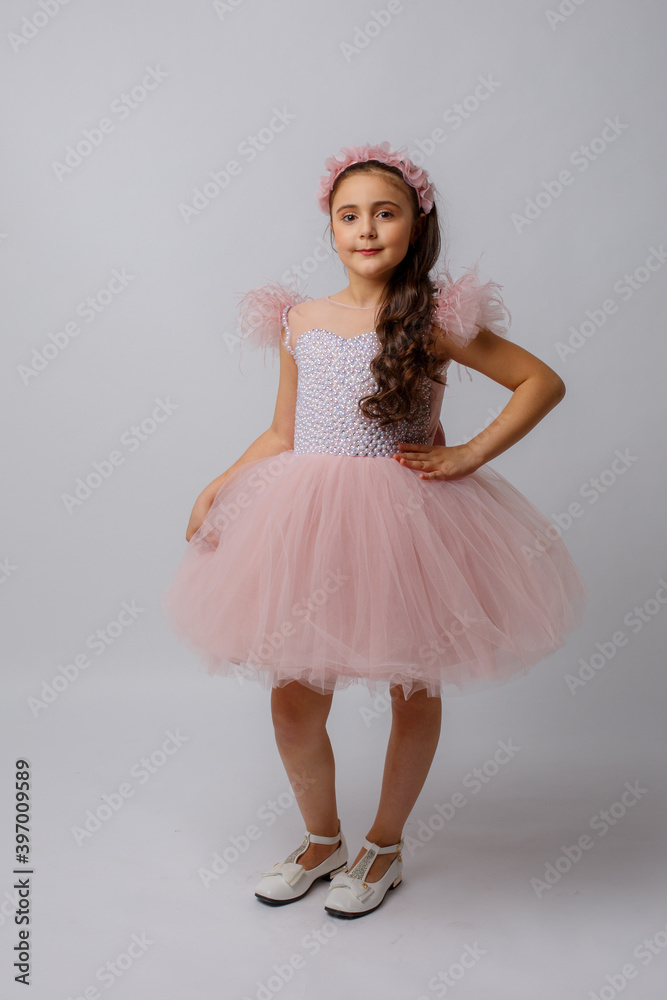 Naklejka premium little girl in a beautiful dress on a white background
