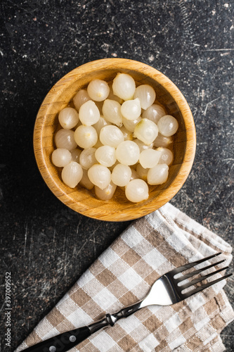 Pickled mini baby onions in wooden bowl.