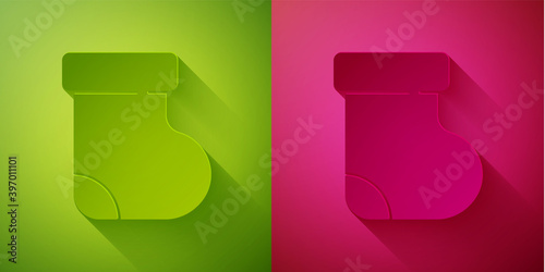 Paper cut Baby socks clothes icon isolated on green and pink background. Paper art style. Vector.