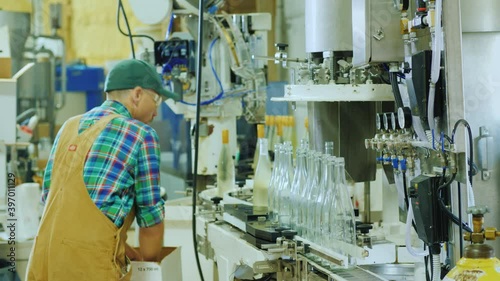 Technician works near the wine bottling conveer photo