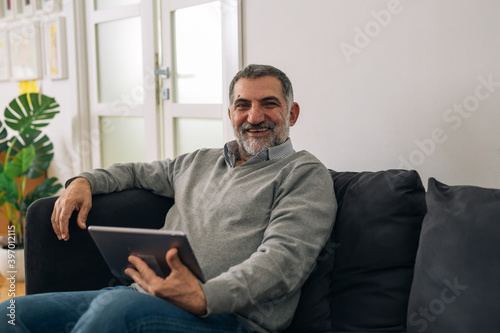 man using digital tablet at his home