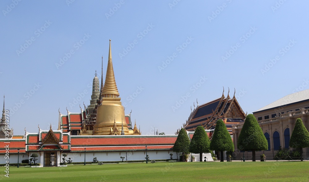 Temple of Emerald Buddha (Wat Phra Kaew) in Bangkok, Thailand with tree branches front isolated on blue sky background closeup. Is the grand palace of general tourists.
