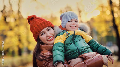 beautiful young mom and little son have fun in the park. family enjoying a walk in nature. happy motherhood concept. soft focus photo