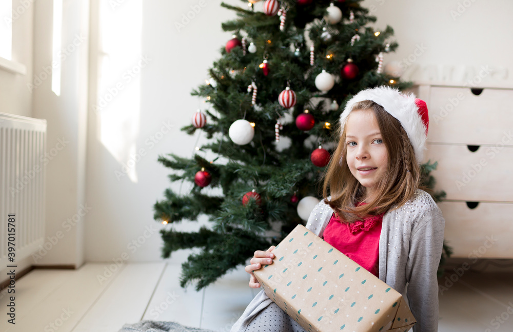 Young pretty girl in santa clause hat with Christmas gifts in front of a Christmas tree with masks Young pretty girl in santa clause hat with Christmas gifts in front of a Christmas tree with masks