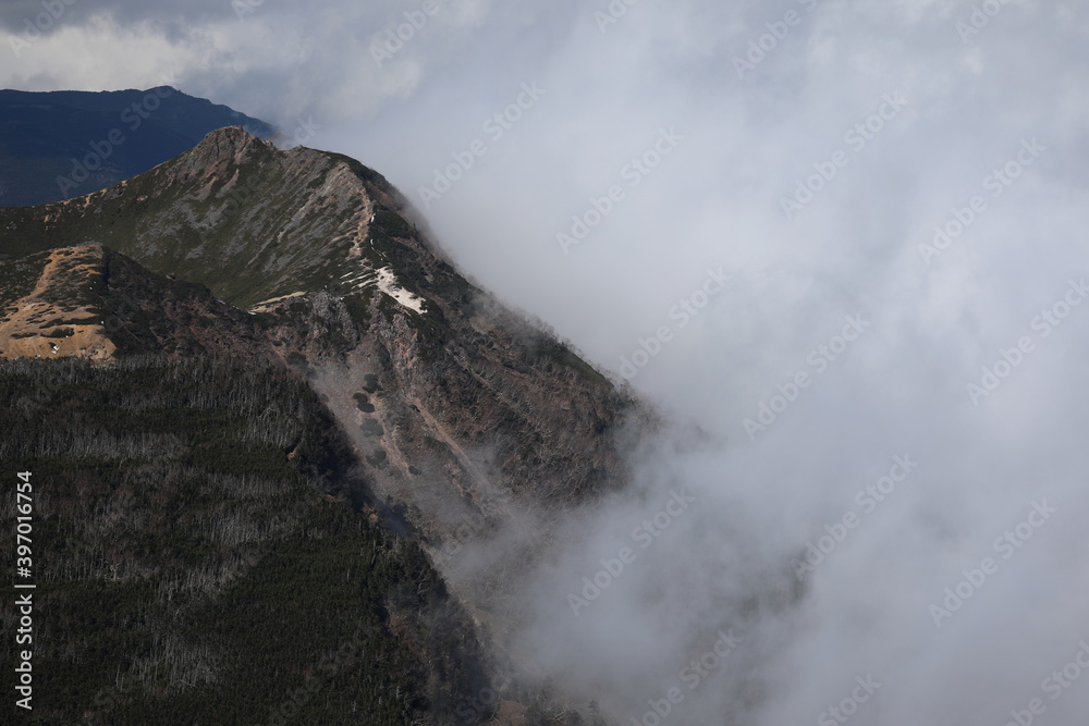 Mountain ridge covered with deep cloud