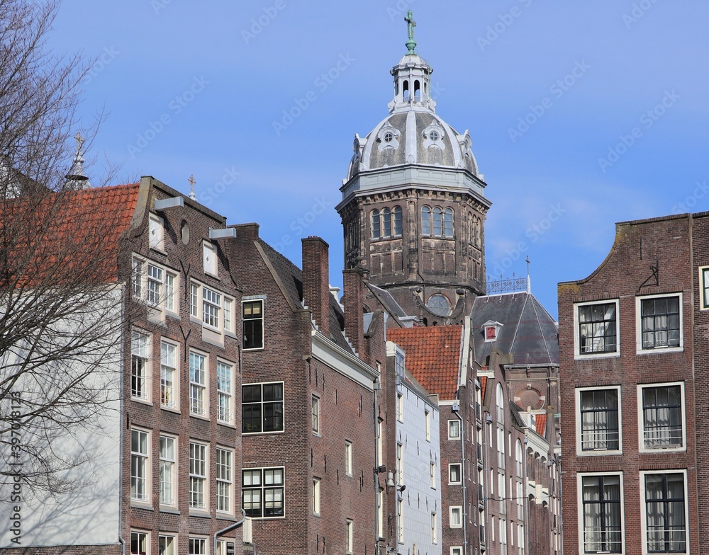 Fototapeta premium Old Canal Houses with Church Tower in Amsterdam's Red Light District
