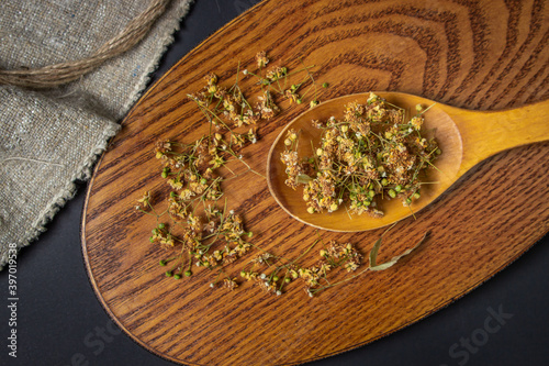 Dried linden on a wooden spoon. Linden on a wooden surface. Healing herbs.