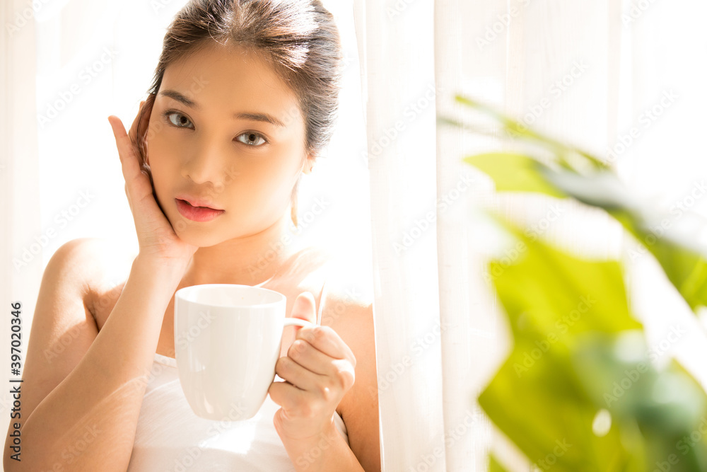 Beautiful woman posing with coffee mug cup inside the room Beautiful woman posing with coffee mug cup inside the room