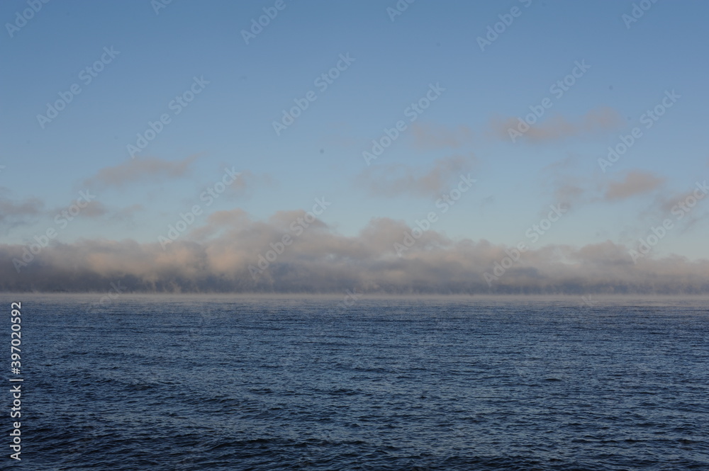 Vapour of haze over Vättern lake in Gränna in Sweden on a sunny winter day with blue sky, clear air and water Vapour of haze over Vättern lake in Gränna in Sweden on a sunny winter day with blue sky, clear air and water