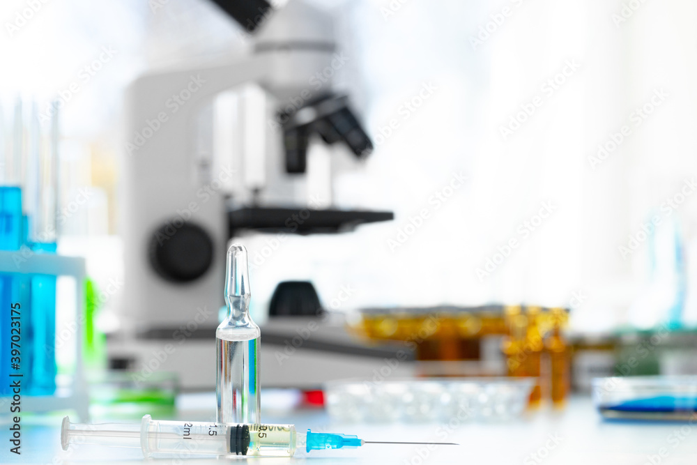 Glass bottle of medication for injections on table Glass bottle of medication for injections on table