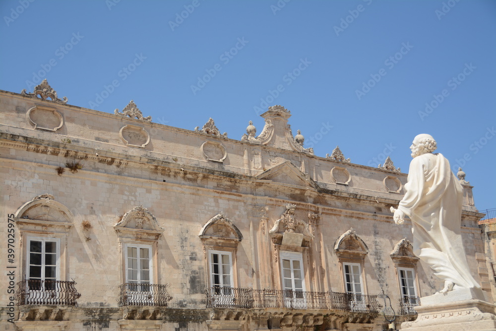 Syracuse is a city in Sicily. Here is the statue of St. Peter in front of the cathedral and the town hall in Duomo  square in the peninsula of Ortigia which is the ancient center. 